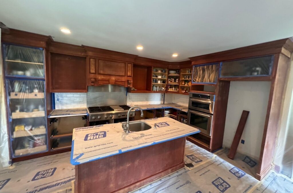 Painter rolling fresh color onto living room wall in occupied Holden home