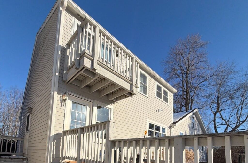 Painter brushing exterior trim on a Natick home after detailed surface preparation