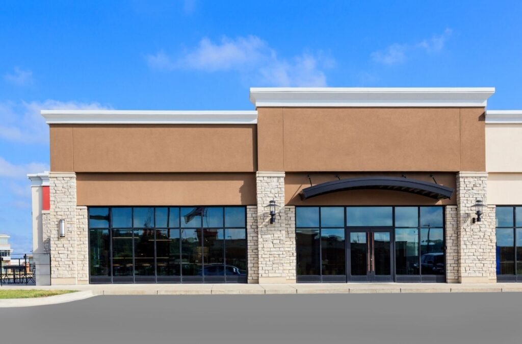 Tan stucco storefront with stone columns, a business space for Lucena Painting commercial painting in Holden, MA
